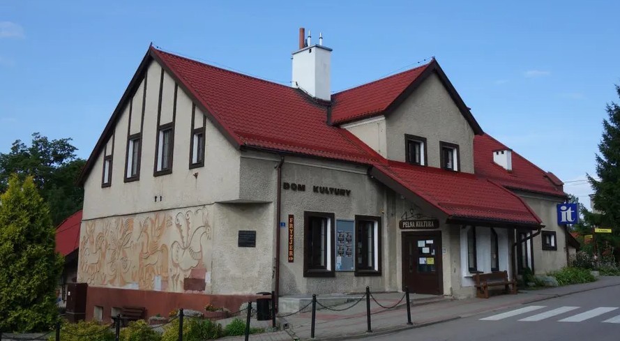 Klienci przeglądają książki w nowoczesnej bibliotece z drewnianymi regałami.